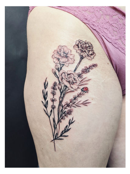 Image of a thigh with a Fine line tattoo of carnations  