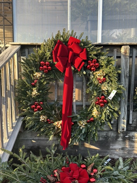 Evergreen Christmas wreath with red bow and ornaments