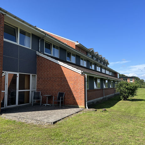 Hotellets renoverede facade med smuk grå mosaikpuds og forvandlet udseende