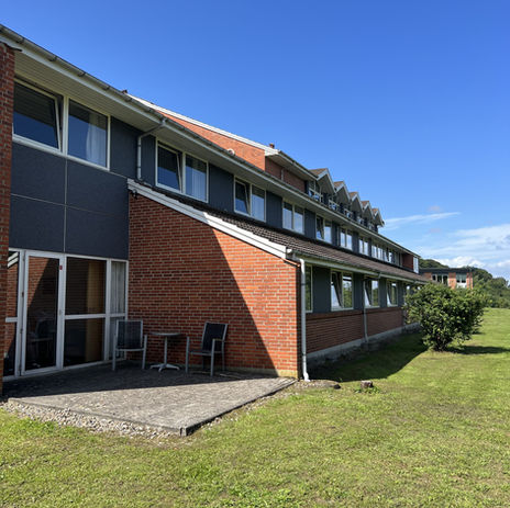 Smuk renoveret hotel facade med elegant grå mosaikpuds