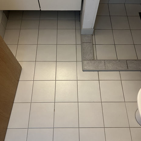 Badeværelse efter renovering med et nyt og opdateret udseende med hvide gulvfliser