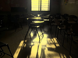 A lone chair sitting in the middle of a classroom