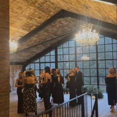 wedding guests all in black under a chandelier