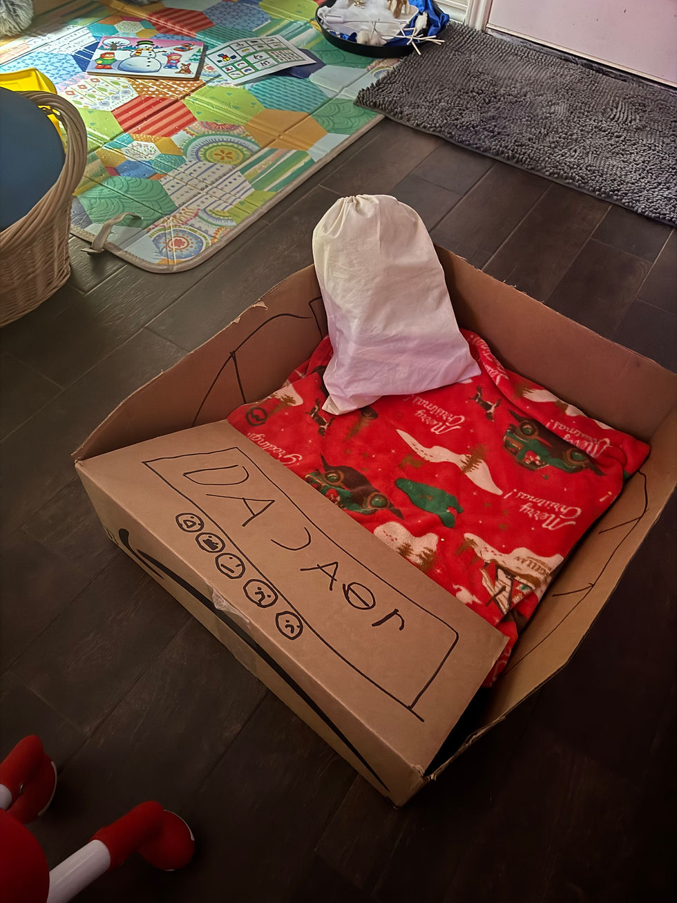 A DIY Santa's Sleigh with a sack of toys and a Christmas blanket inside.