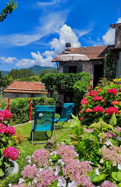 Esterno in pietra e giardino fiorito del Little Gem Chaket a Piazzaga, Torno