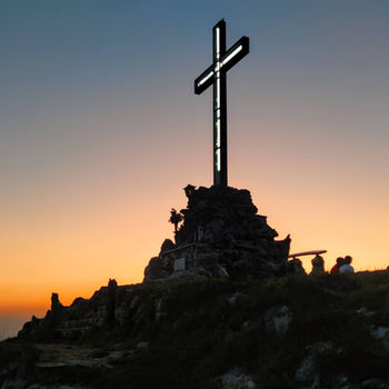Croce di vetta Monte Bolletone illuminata dai colori del post tramonto, cielo notturno terso sullo sfondo