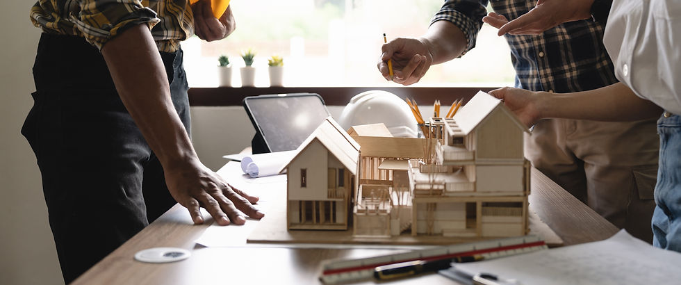 An architect looks over house plans and a model