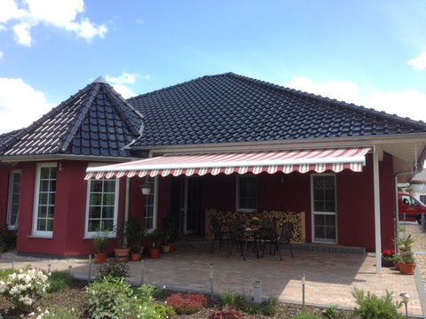 Rot-weiß gestreifte Markise an rotem Haus