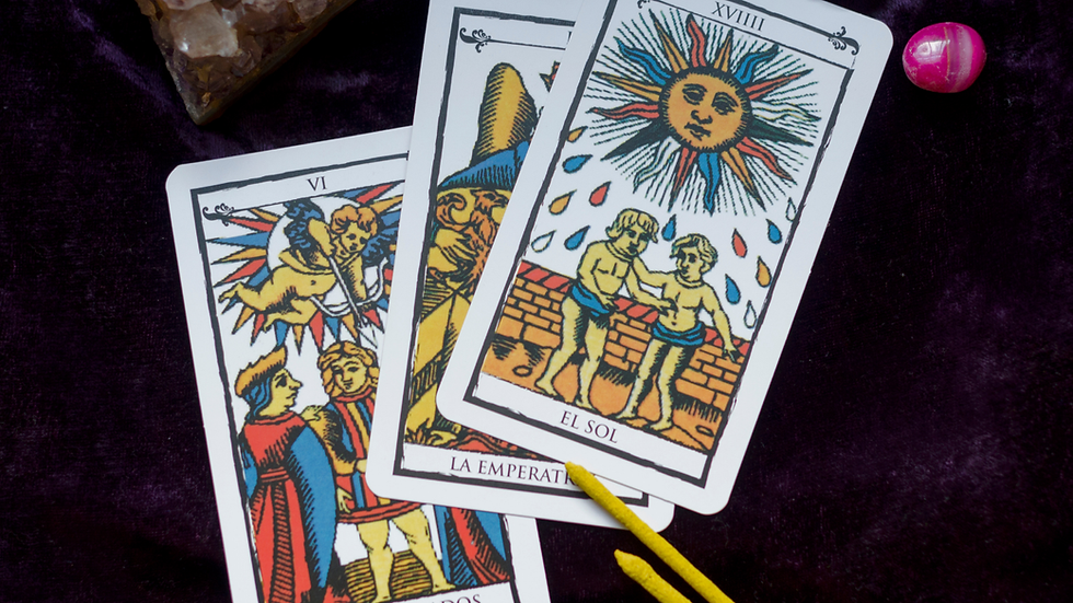 Tarot cards including The Lovers, The Empress, and The Sun arranged on a purple cloth with crystals and incense sticks.