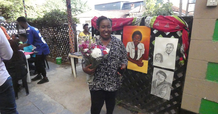 Ciru Ivy standing beside some portraits