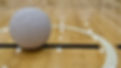 A ground level view of a Netball Ball positioned left of shot, placed within the centre ci