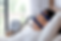 Man sleeping with a CPAP mask in bed, white sheets, machine on bedside table, bright room, calm and restful setting.