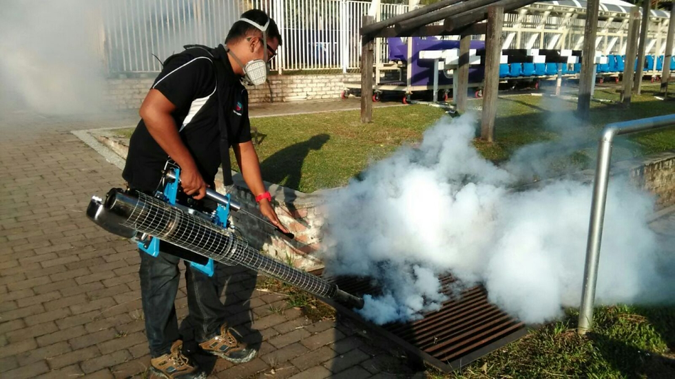 Juruteknik kawalan serangga menyembur racun perosak di sekeliling perimeter rumah di Kuala Lumpur.