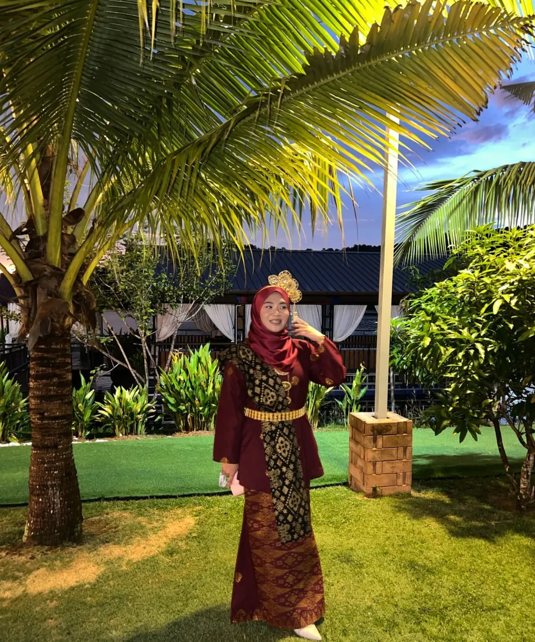 Girl in maroon traditional Malay outfit with hair accessories
