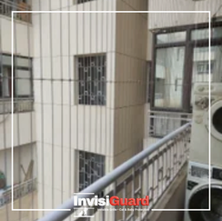 Cat sitting safely near condo balcony protected with invisible grille