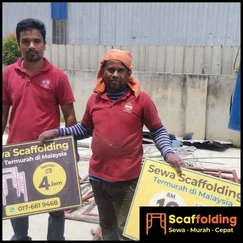 Pekerja pembinaan memakai peralatan keselamatan penuh dan harness scaffolding