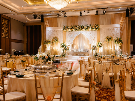 Luxurious wedding hall setup with banquet tables and elegant pelamin