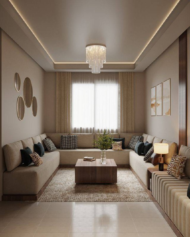 Elegant living room with L-Box Plaster Ceiling, beige sofas, black and patterned cushions, wooden coffee table, and chandelier. Neutral colors, cozy ambiance.