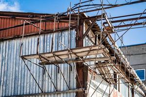 Scaffolding size being measured on-site to match building height requirements.