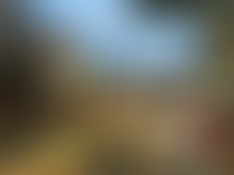 Crowded street food market with food trucks, tables, and people dining outdoors. Historic building and cityscape in the background.