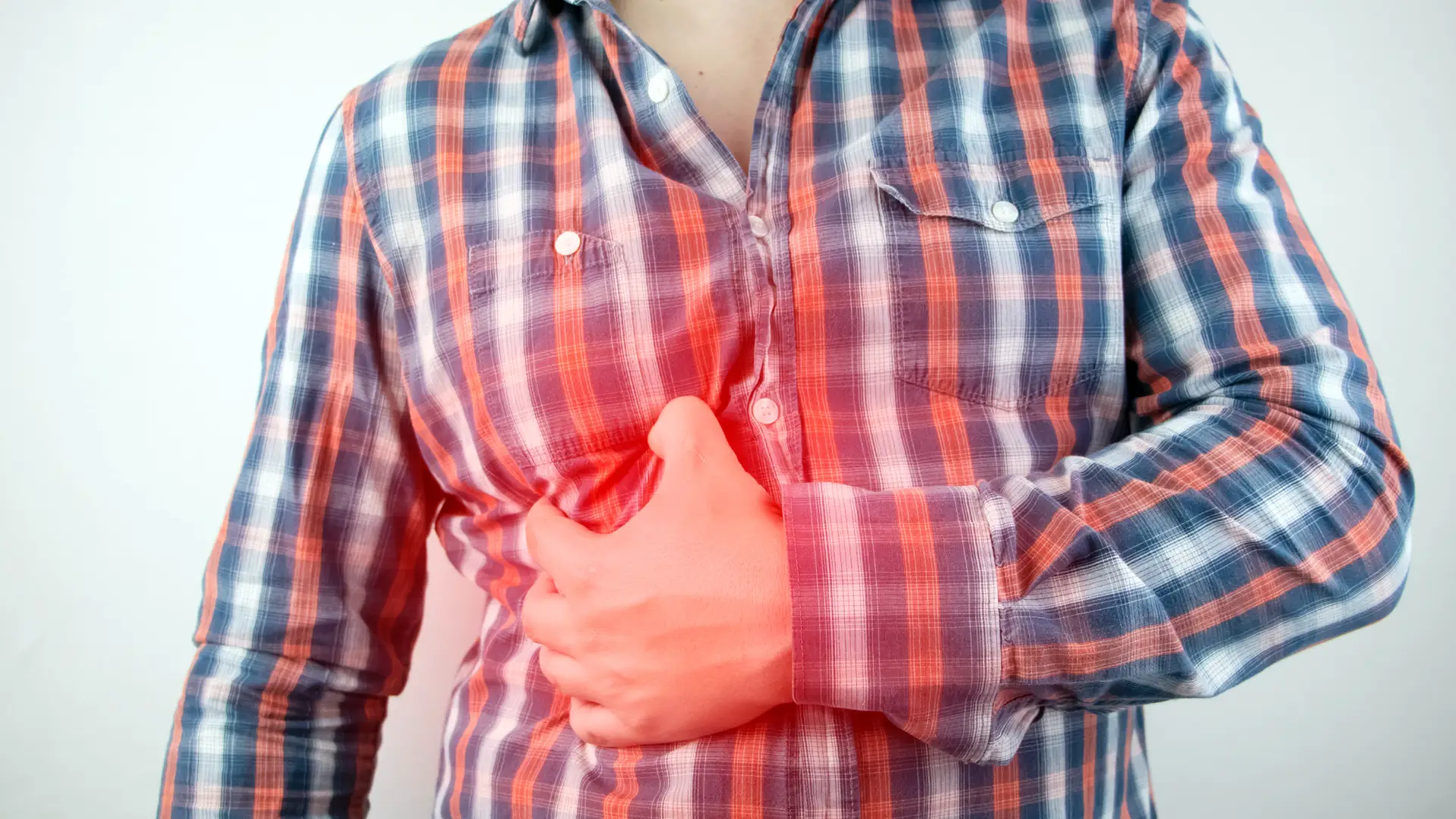 A man holds the side of his stomach in pain.