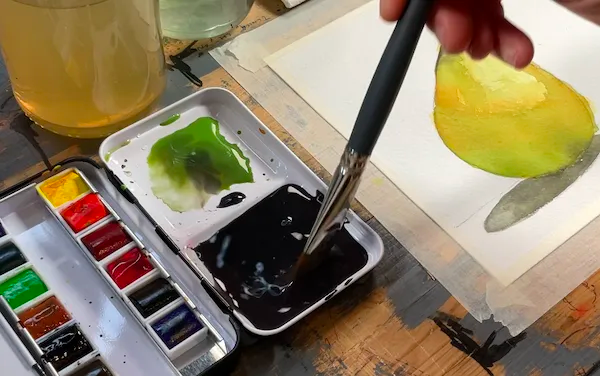 preparazione del colore sullo sfondo su una palette di acquerelli con pennello