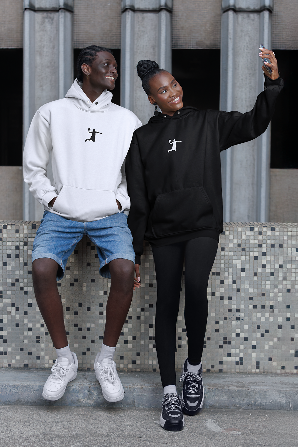 jeune couple noir -dans la rue- portant le même hoodie imprimé du logo blanc 'Player Shadow' milieu devant