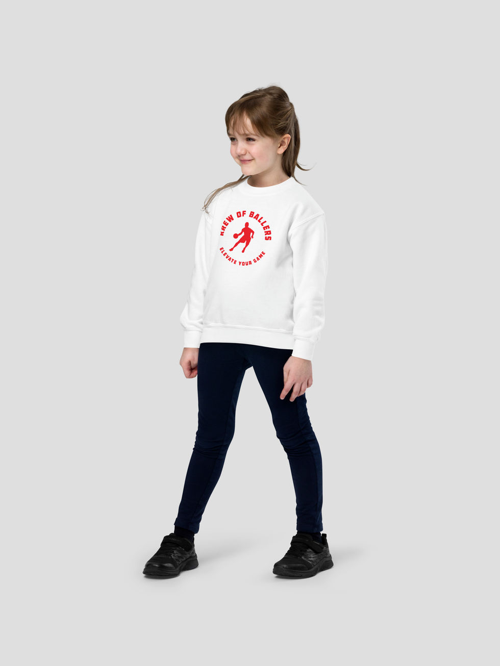 vue de face d'une fillette en studio posant dans le sweatshirt blanc imprimé "eleveate your game" en rouge de Frenchborn
