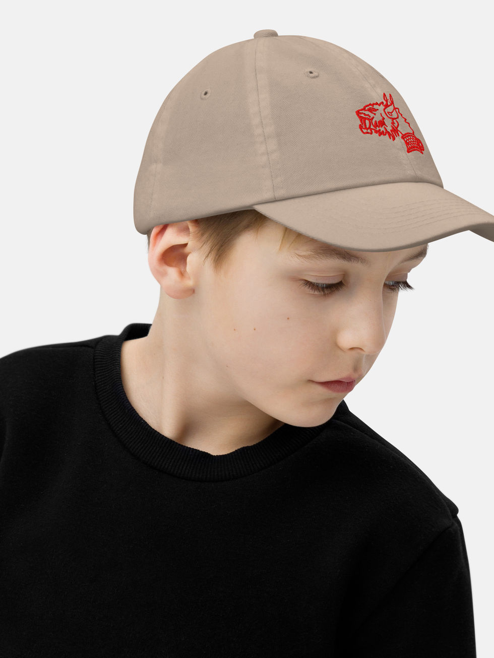 garçon portant une casquette beige kakibrodée en rouge d'une tête de lion en rouge sur le devant