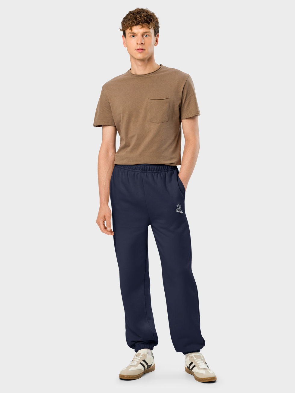 de face, jeune homme en t-shirt marron et jogger en molleton bleu marine brodé mascotte frenchborn en blanc sous poche