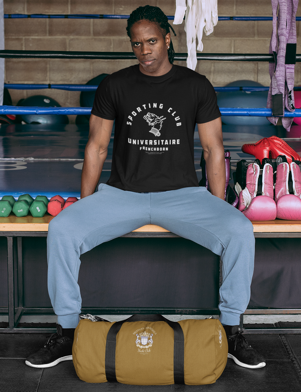 homme noir présentant un tee-shirt noir imprimé du logo blanc du Sporting Club Universitaire Frenchborn