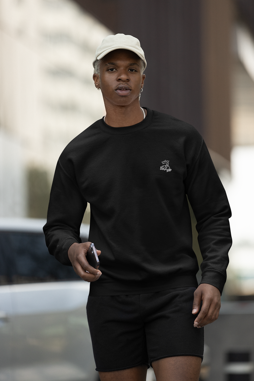 homme citadin portant un sweatshirt noir brodé Mascotte blanc côté coeur avec un short noir
