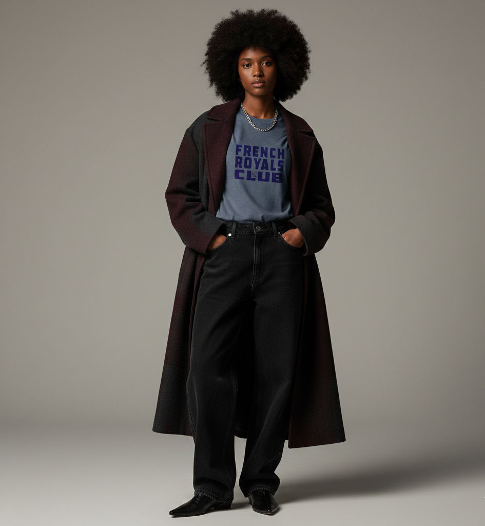 femme afro posant en t-shirt French Royals Club et jean baggy noir sous un long manteau cicolore foncé
