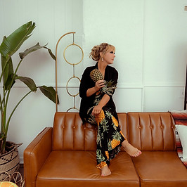 Portrait of Kiley George holding a pineapple, symbolizing her work as a relationship coach and non-monogamy advocate.
