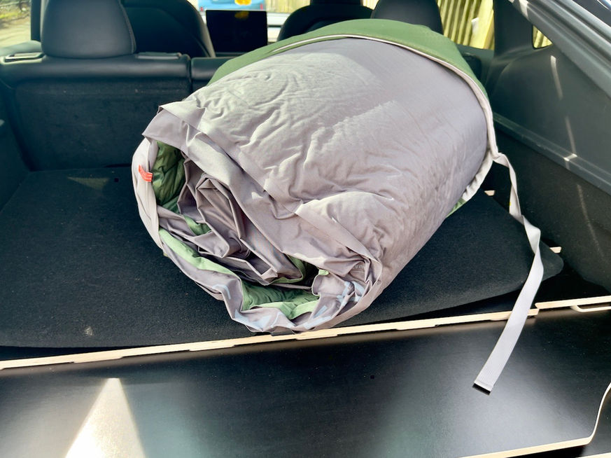 Camping mattress rolled up in the trunk.