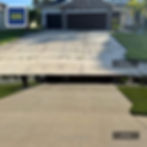 Before and after concrete driveway cleaning in Palmetto, FL removing heavy black algae buildup.