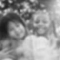 Black and white image of two happy little girls, friends, in the park.
