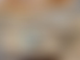 Elegant kitchen with large marble island, white cabinetry, and ornate chandeliers. Warm smart lighting, beige tones, and a snowy view outside.