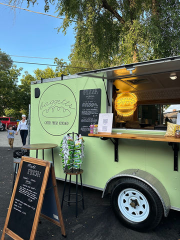 a green food truck that says pizza on it