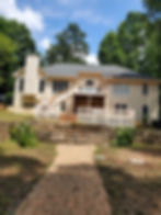 Large house exterior with deck and brick path