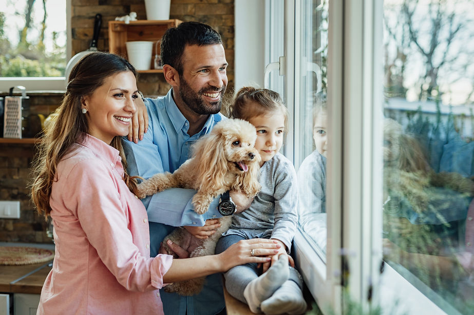 young-happy-family-their-dg-relaxing-by-window-home-looking-through-it.jpg