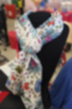 White scarf with colorful doodle pattern on display