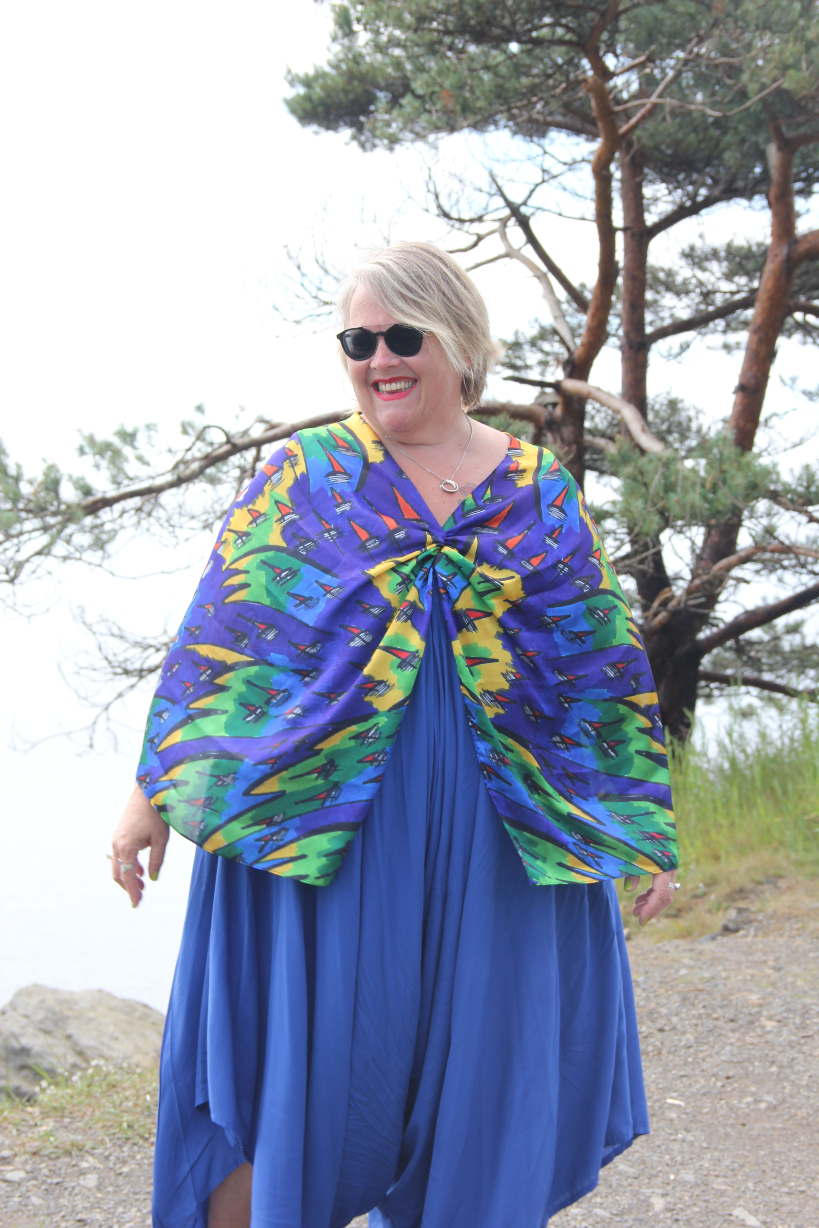 Smiling woman in vibrant abstract blue and green patterned top