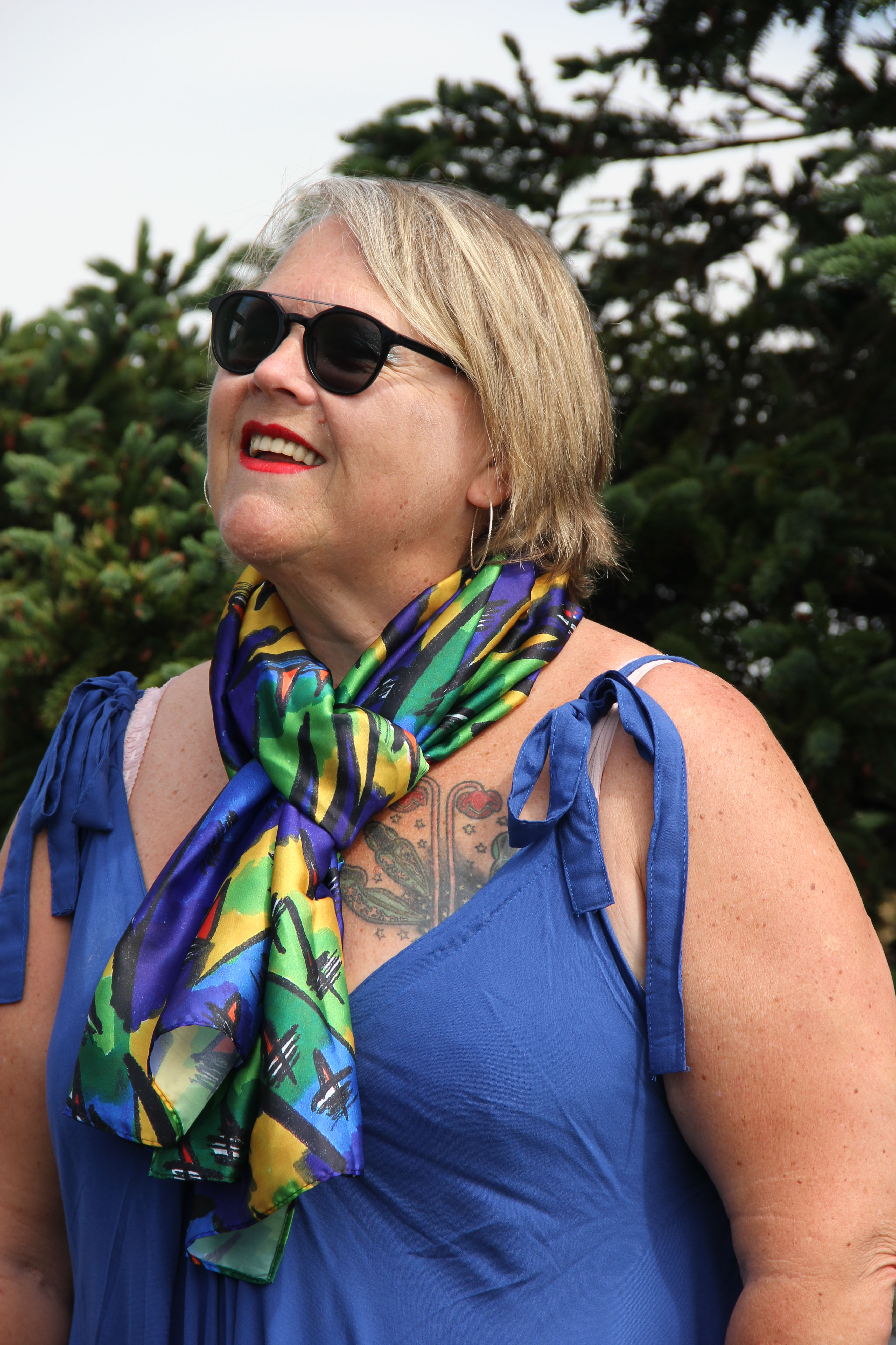 Smiling woman in sunglasses wearing The Maple Leaf One scarf