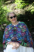 Smiling woman wearing sunglasses and a colorful patterned poncho