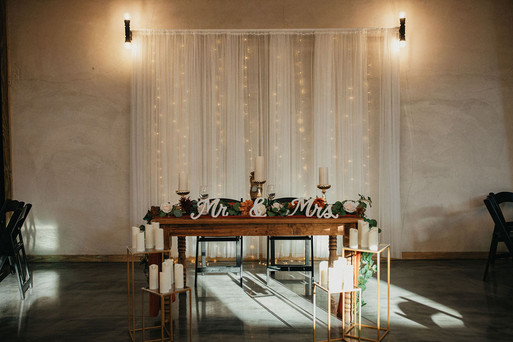 Sweetheart table with candles and string lights backdrop at Houston reception.