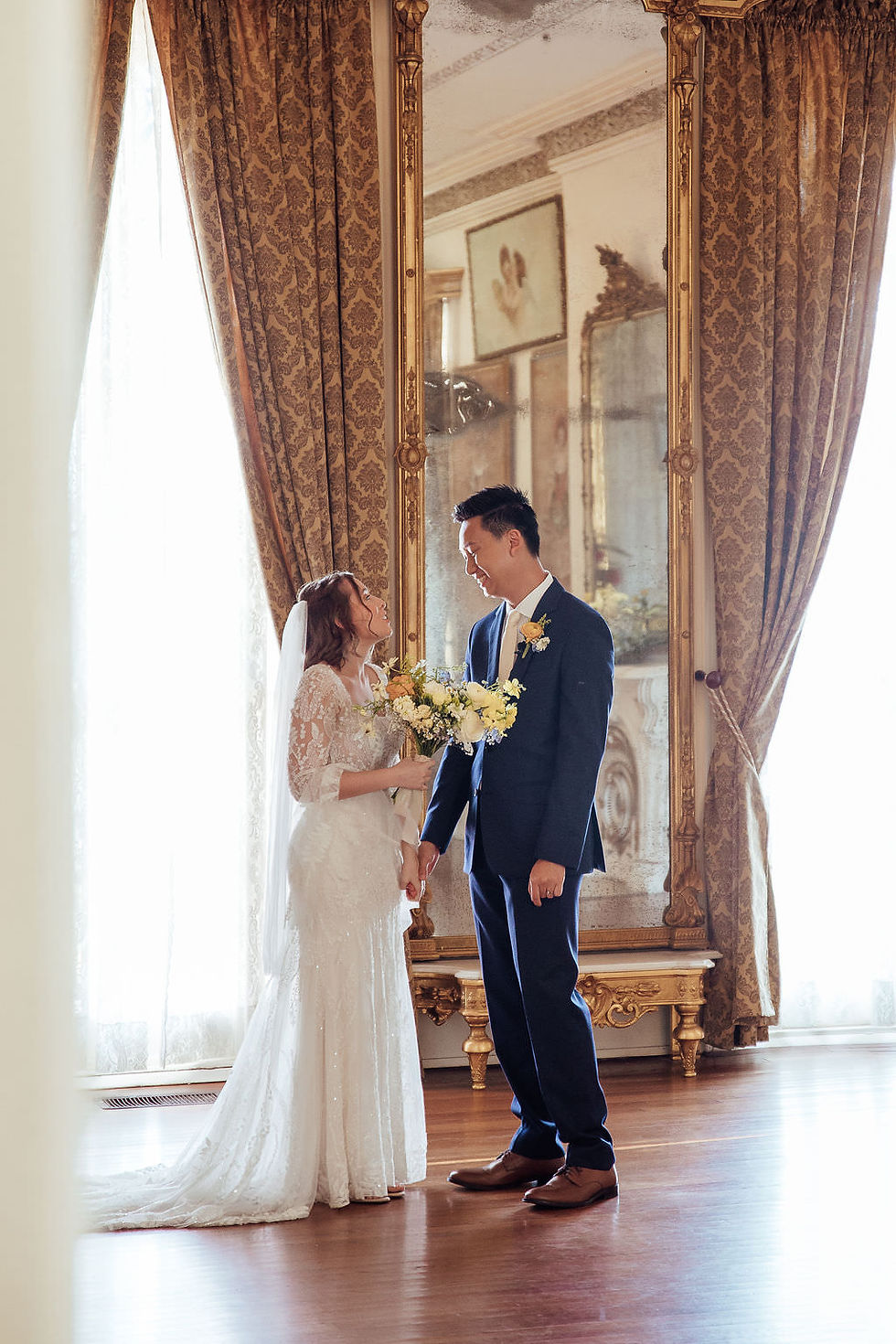 Bride and groom share a quiet moment at Ashton Villa with golden curtains and elegant decor in Houston.