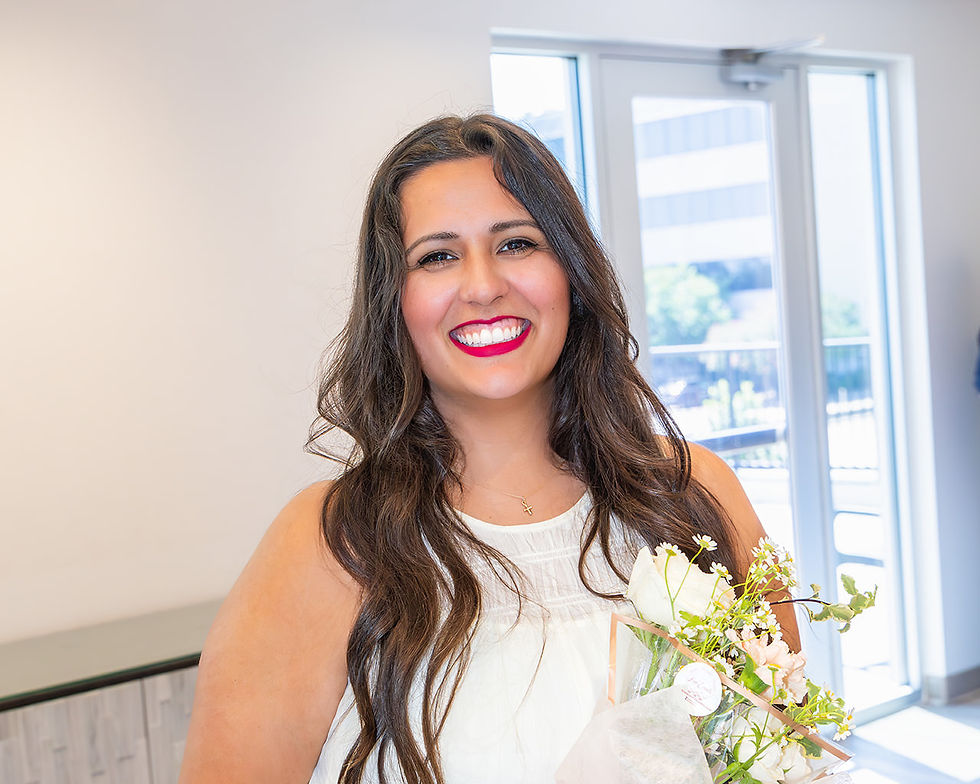 Brandi Swanson, wedding planner, holding a bouquet indoors and smiling
