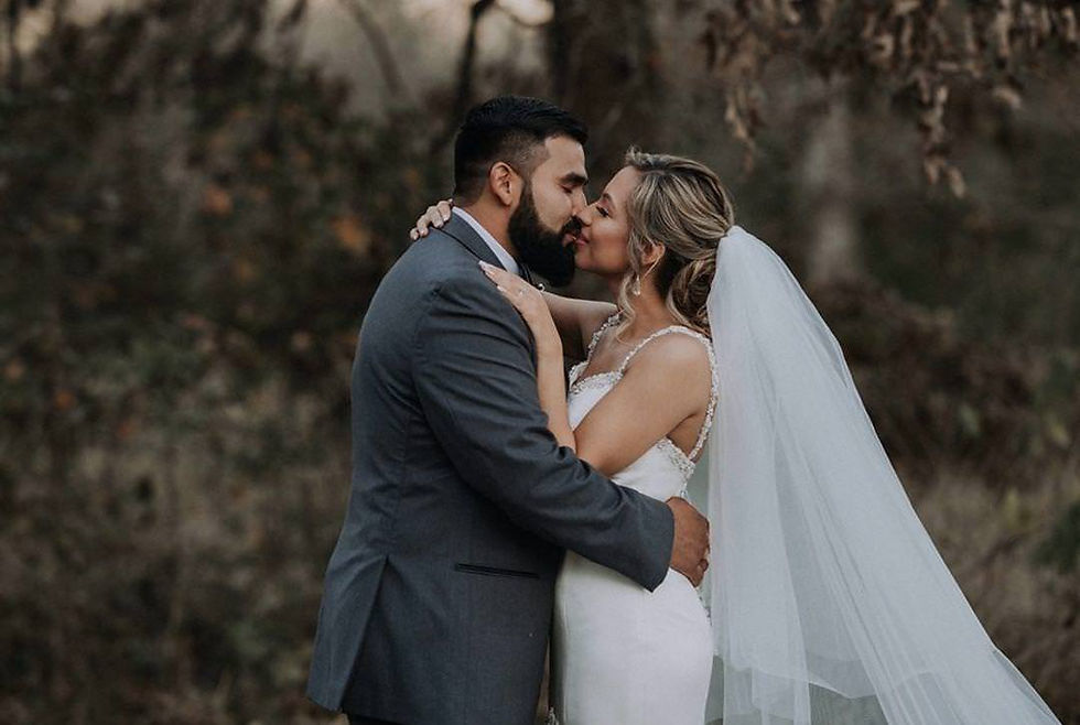 Bride and groom share a kiss outdoors.