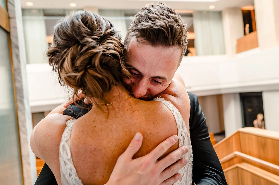 A couple embraces warmly after joyful emotions of seeing each other in first look
